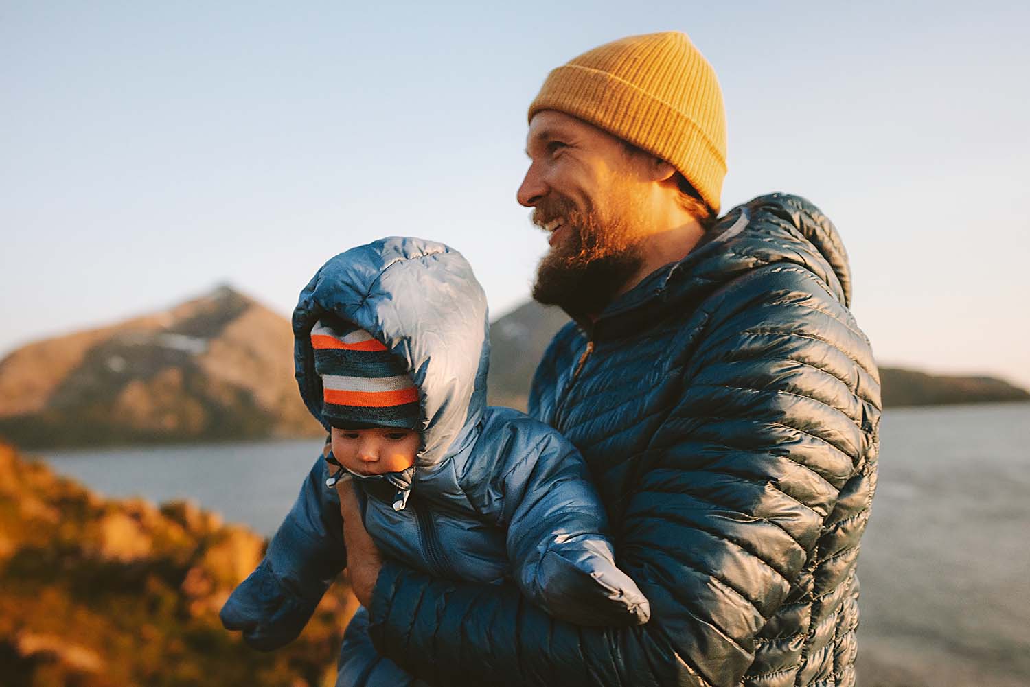 Mid 30s man holding a baby in winter Tasmania.